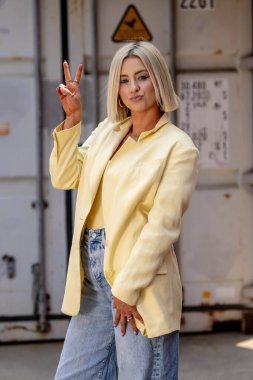 Sarışın bir model yaz havasının tadını çıkarırken dışarıda poz veriyor.