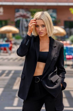 Sarışın bir model yaz havasının tadını çıkarırken dışarıda poz veriyor.