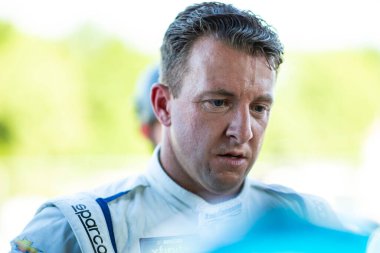 AJ Allmedinger, Elkhart Gölü 1. Dünya Savaşı 'nda Road America 180' de yapılacak elemeler sırasında zamanlama standına bakıyor..