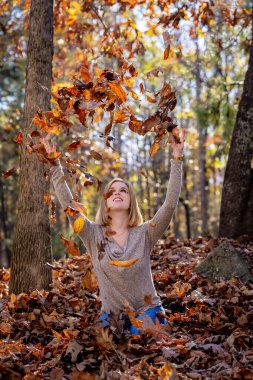 Muhteşem bir sarışın model açık havada sonbahar havasının tadını çıkarıyor.