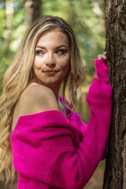 Muhteşem bir sarışın model açık havada sonbahar havasının tadını çıkarıyor.