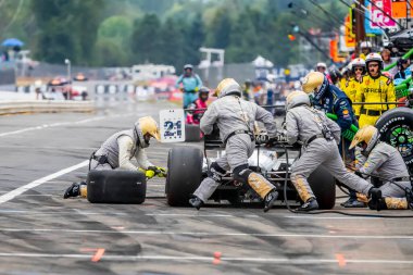 Hollanda, Hoofddorp 'tan INDYCAR Serisi sürücüsü RINUS VEEthe 21 Portland' daki Portland Uluslararası Yarış Pisti 'nde Bitnile.com Grand Prix sırasında hizmet için arabasını getirir..