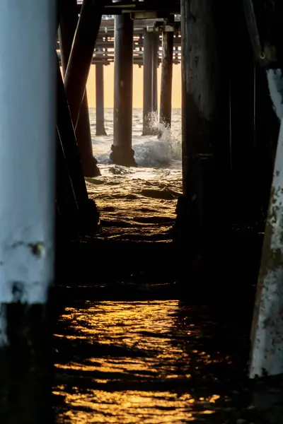 Vlny Narážejí Molo Když Slunce Zapadá Oceánu — Stock fotografie