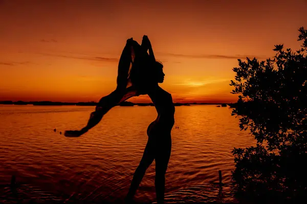 A gorgeous latin model poses as the sun rises over the Gulf of Mexico near Sinanche Yucatan Mexico