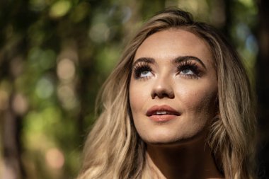 Muhteşem bir sarışın model açık havada sonbahar havasının tadını çıkarıyor.