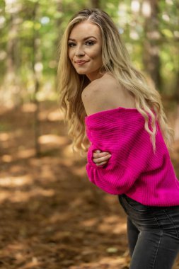 Muhteşem bir sarışın model açık havada sonbahar havasının tadını çıkarıyor.