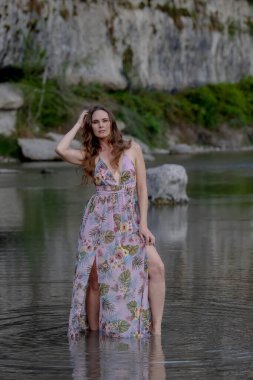 Muhteşem bir esmer model göl kenarındaki yaz havasının tadını çıkarıyor.