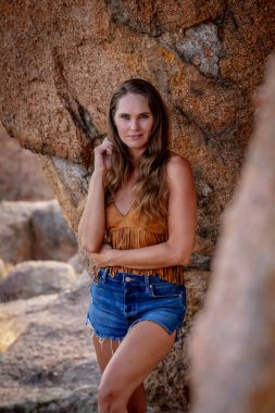 Muhteşem bir esmer model, sonbahar havasının tadını çıkarırken dışarıda poz veriyor.