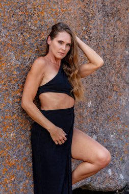 Muhteşem bir esmer model, sonbahar havasının tadını çıkarırken dışarıda poz veriyor.