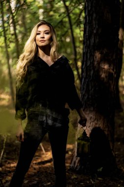 Muhteşem bir sarışın model açık havada sonbahar havasının tadını çıkarıyor.