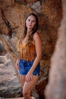 Muhteşem bir esmer model, sonbahar havasının tadını çıkarırken dışarıda poz veriyor.