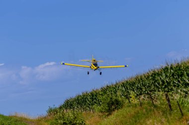 Alçaktan uçan ekin ilaçlayıcıları zararlılarla savaşıyor, böcek kontrolü için hassas kimyasal spreylerle tarlaları koruyor, sağlıklı mahsul verimini sağlıyordu..