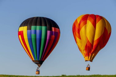 Göz kamaştırıcı balonlar mavi gökyüzünde dans eder, canlı renklerle dolu bir gösteri gökyüzünde neşeyle süzülür