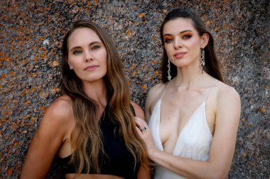 İki çarpıcı model, doğadaki zengin duvar halısı ve güzelliğin ortasında poz veriyor..