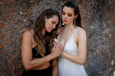 İki çarpıcı model, doğadaki zengin duvar halısı ve güzelliğin ortasında poz veriyor..