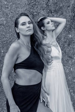 İki çarpıcı model, doğadaki zengin duvar halısı ve güzelliğin ortasında poz veriyor..