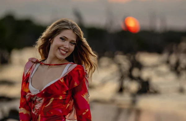 In the vibrant Mexican tropics, a stunning woman strikes a pose amidst lush greenery as the Yucatan sun sets, casting its golden glow on nature's canvas.