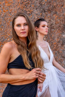 İki çarpıcı model, doğadaki zengin duvar halısı ve güzelliğin ortasında poz veriyor..