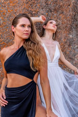 İki çarpıcı model, doğadaki zengin duvar halısı ve güzelliğin ortasında poz veriyor..