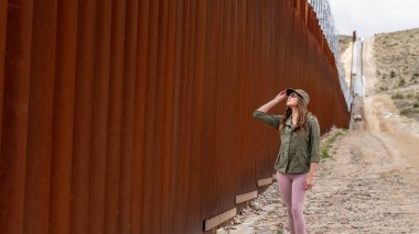 Desperate migrant navigates the Jacumba border wall, seeking illegal entry into the United States, highlighting ongoing immigration challenges clipart