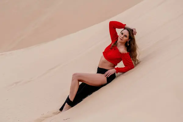 stock image Graceful model embraces nature's beauty in the sand dunes, epitomizing elegance against the backdrop of vast, natural splendor