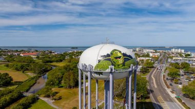 Dunedin 'in yukarısında, FL: Havadan bakan canlı boyalı kaplumbağalar ikonik Dunedin su kulesini süslüyor, Florida ufuk çizgisine renk ve cazibe katıyor.