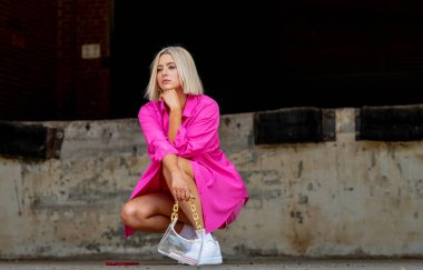 Sarışın bir model yaz havasının tadını çıkarırken dışarıda poz veriyor.