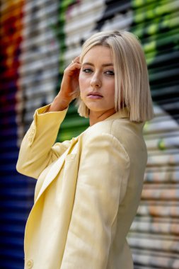 Sarışın bir model yaz havasının tadını çıkarırken dışarıda poz veriyor.