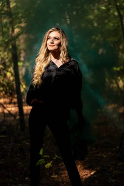 Muhteşem bir sarışın model açık havada sonbahar havasının tadını çıkarıyor.