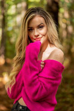 Muhteşem bir sarışın model açık havada sonbahar havasının tadını çıkarıyor.