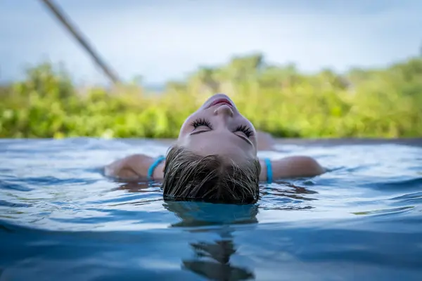 stock image Young bikini model luxuriates in warm sun, cool pool, Yucatan Mexico vacation.