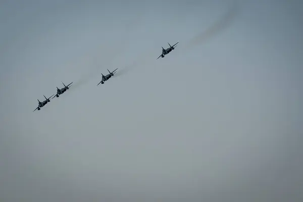 stock image A group of military airplanes perform a thrilling flyover above the Iowa Speedway, right after the national anthem, marking the start of the Hy-Vee Homefront 250 with a patriotic display.