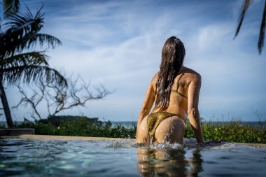 Genç bikini modeli sıcak güneşte lüks, serin havuz, Yucatan Meksika tatili.