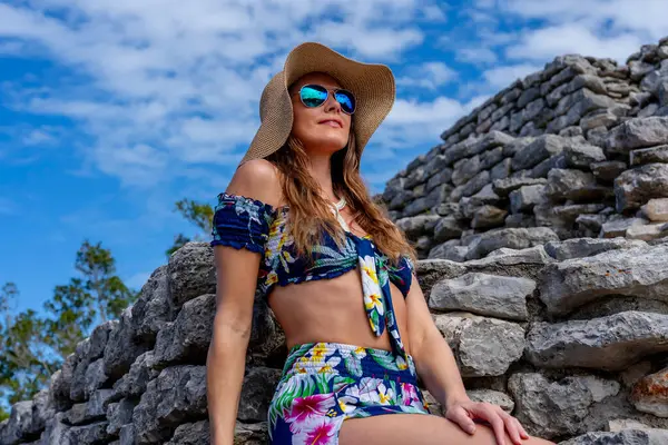 stock image A radiant young woman explores the Xcambo Mayan ruins, her presence weaving elegance with ancient history, under the Caribbean sun's golden embrace