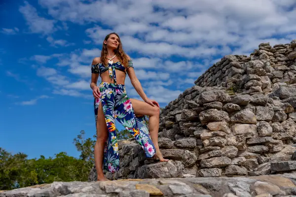 stock image A radiant young woman explores the Xcambo Mayan ruins, her presence weaving elegance with ancient history, under the Caribbean sun's golden embrace