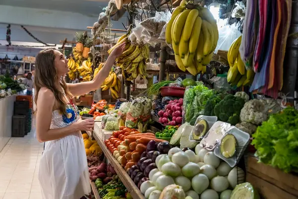 stock image A lovely young woman explores a charming shop in Telchec, Mexico, nestled in the Yucatan Peninsula's quaint town, captivated by its rustic allure.