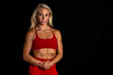 Göz kamaştırıcı atletik formda bir model stüdyoda güven içinde poz veriyor, yumuşak ışıklandırmayla vurgulanmış kasları. Gücünü ve zarafetini sergiliyor. Göz kamaştırıcı fiziğini göstererek gösterişli, minimalist bir ortamda..