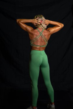 Göz kamaştırıcı atletik formda bir model stüdyoda güven içinde poz veriyor, yumuşak ışıklandırmayla vurgulanmış kasları. Gücünü ve zarafetini sergiliyor. Göz kamaştırıcı fiziğini göstererek gösterişli, minimalist bir ortamda..