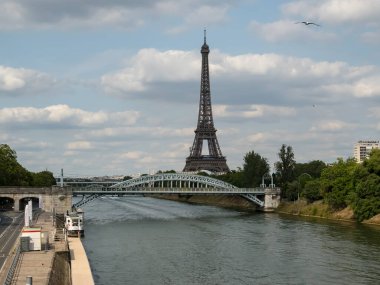 Paris 'teki Eyfel Kulesi, Olimpiyat yüzükleriyle süslenmiş, 2024 Yaz Olimpiyatları için göz alıcı bir süs olarak parlıyor, ikonik gökyüzüne karşı oyunların ruhunu ve birliği simgeliyor..