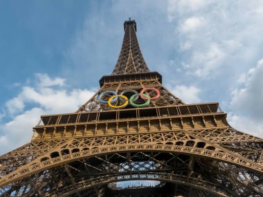 Paris 'teki Eyfel Kulesi, Olimpiyat yüzükleriyle süslenmiş, 2024 Yaz Olimpiyatları için göz alıcı bir süs olarak parlıyor, ikonik gökyüzüne karşı oyunların ruhunu ve birliği simgeliyor..