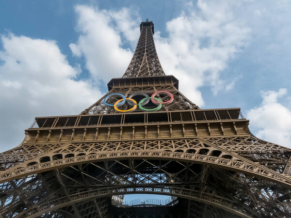 The Eiffel Tower in Paris, adorned with the Olympic rings, shines as a spectacular centerpiece for the 2024 Summer Olympics, symbolizing unity and the spirit of the games against the iconic skyline.