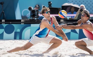 ABD Blocker CHASE BUDINGER (ABD) (2) ve ABD Savunma oyuncusu MILES EVANS (ABD) (1), Stade Tour Eiffel Stadyumu 'nda Fransa' ya (FRA) karşı oynadıkları ön tur Fool F Mens Beach Voleybol karşılaşmasında top için daldılar.