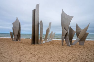 Omaha Sahili 'nde çarpıcı bir anıt olan Les Braves, D-Day kahramanlarını üç unsurla onurlandırdı: Umut, Özgürlük ve Kardeşlik. 6 Haziran 1944 'ten beri süregelen birlik, cesaret ve kardeşliği sembolize eder..