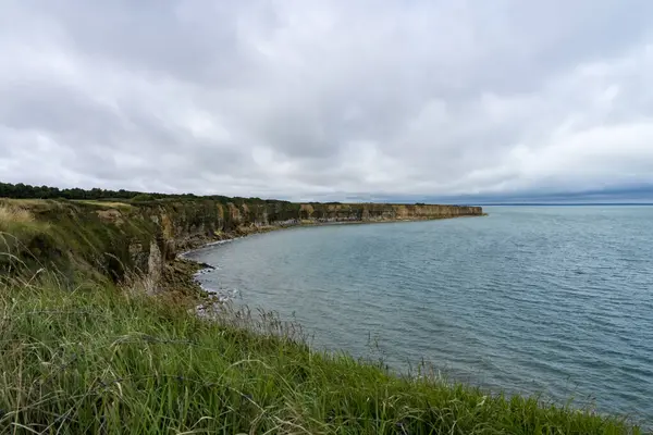 Omaha Sahili 'nin kumlarında yürüyen Normandiya Çıkarması' nın şiddetli çarpışmasının yankıları havada duruyor. Dalgalar bir zamanlar askerlerin savaştığı yere çarpar. Denizin enginliği, cesaret ve fedakârlığın kutsal anılarıyla çelişiyor..