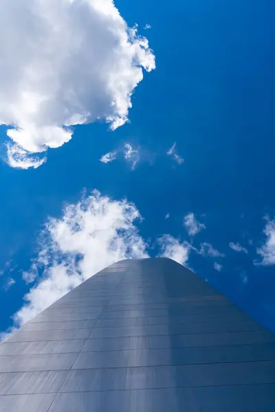 stock image The Gateway Arch in St. Louis, a 630-foot stainless steel monument, forms a gleaming catenary curve against the sky. Towering over the Mississippi River, it symbolizes U.S. westward expansion and draws countless visitors.