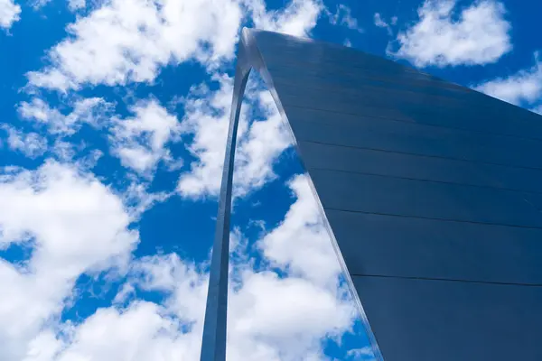 stock image The Gateway Arch in St. Louis, a 630-foot stainless steel monument, forms a gleaming catenary curve against the sky. Towering over the Mississippi River, it symbolizes U.S. westward expansion and draws countless visitors.