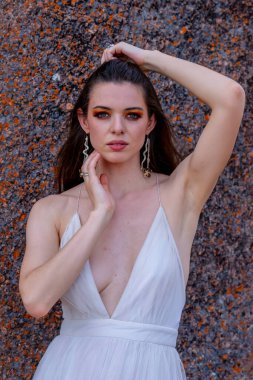 Muhteşem bir esmer model, sonbahar havasının tadını çıkarırken dışarıda poz veriyor.