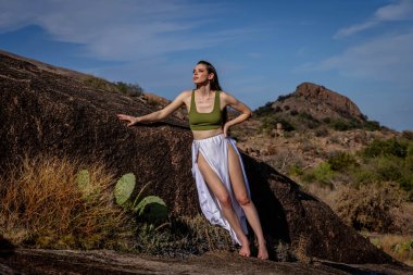 Muhteşem bir esmer model, sonbahar havasının tadını çıkarırken dışarıda poz veriyor.