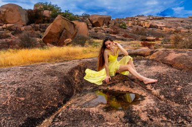 Muhteşem bir esmer model, sonbahar havasının tadını çıkarırken dışarıda poz veriyor.