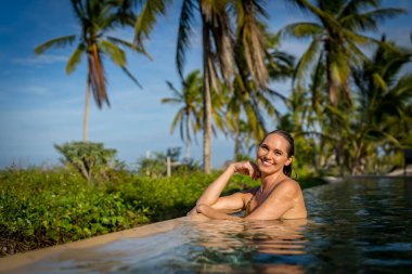 Genç bikini modeli sıcak güneşte lüks, serin havuz, Yucatan Meksika tatili.